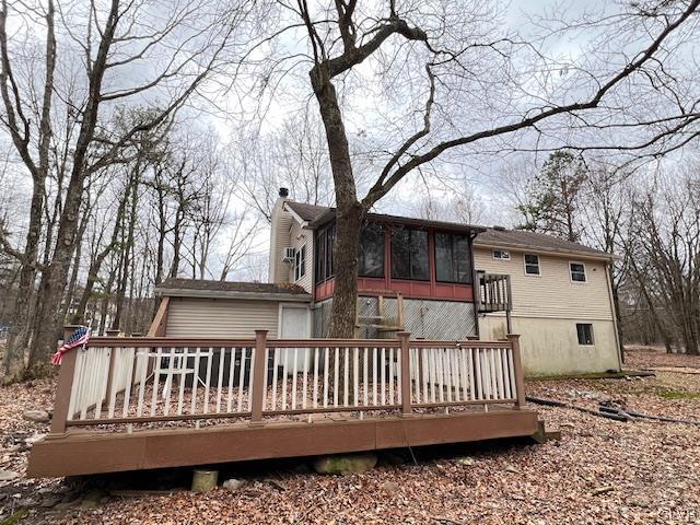 rear view of property with a wooden deck and a sunroom