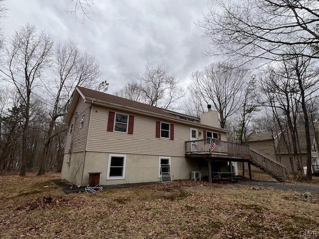 back of property with central AC and a deck