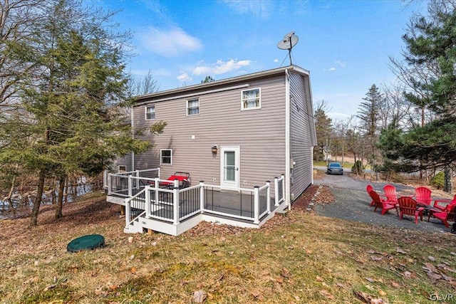 rear view of house with a deck and a lawn