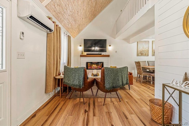 interior space with lofted ceiling, an AC wall unit, light wood-type flooring, and plenty of natural light