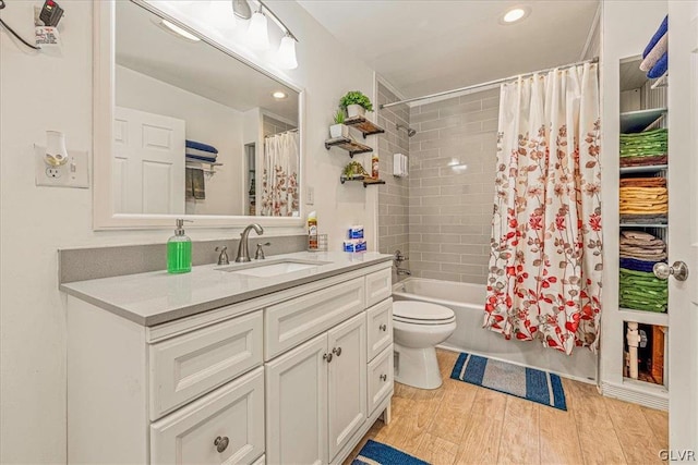 full bathroom featuring toilet, hardwood / wood-style floors, vanity, and shower / tub combo with curtain