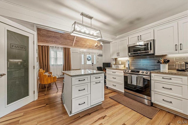 kitchen with appliances with stainless steel finishes, light hardwood / wood-style flooring, and white cabinetry