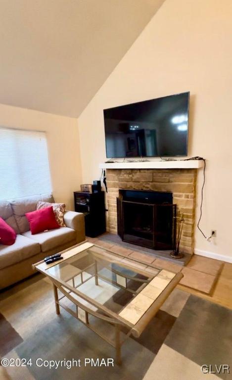 living room featuring a fireplace and vaulted ceiling