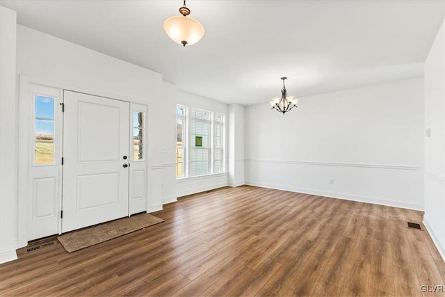 foyer entrance featuring hardwood / wood-style floors and an inviting chandelier