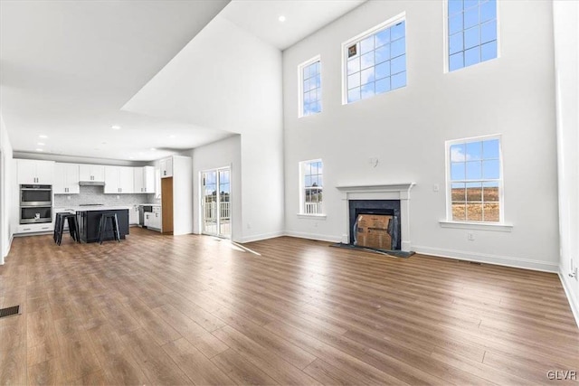 unfurnished living room with a wealth of natural light and wood-type flooring