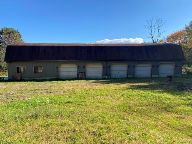 view of outbuilding with a lawn and a garage