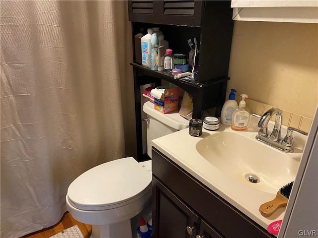 bathroom featuring walk in shower, vanity, and toilet