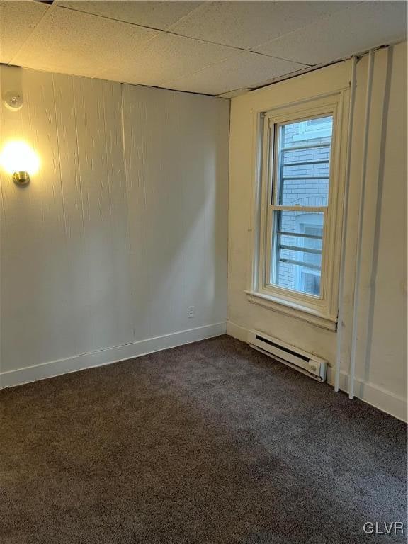 carpeted empty room with a baseboard radiator