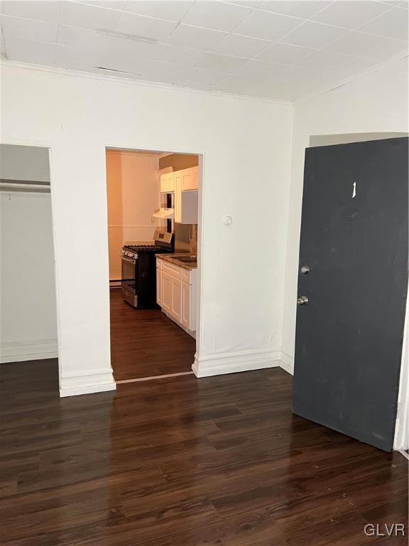 spare room featuring ornamental molding and dark hardwood / wood-style flooring