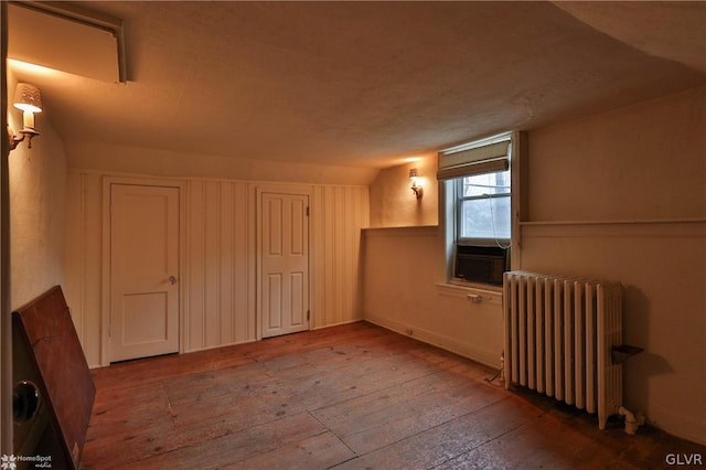 bonus room with a textured ceiling, radiator, and hardwood / wood-style flooring