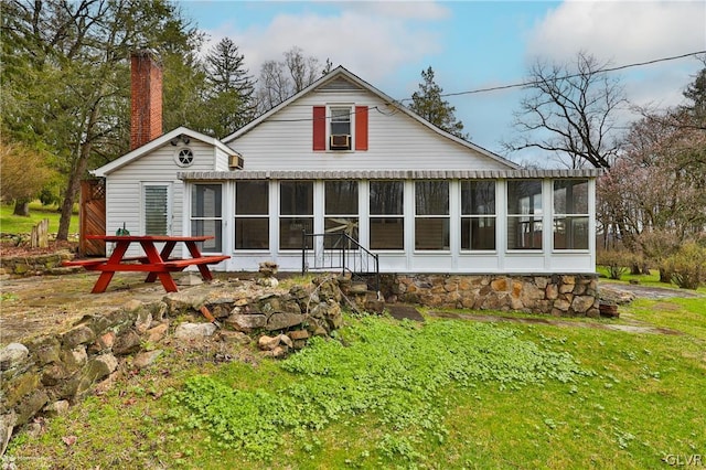 back of house with a yard and a sunroom