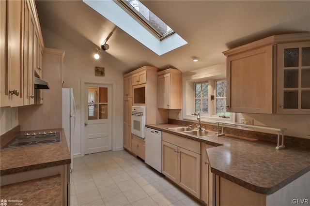 kitchen featuring light brown cabinets, white appliances, sink, and lofted ceiling with skylight