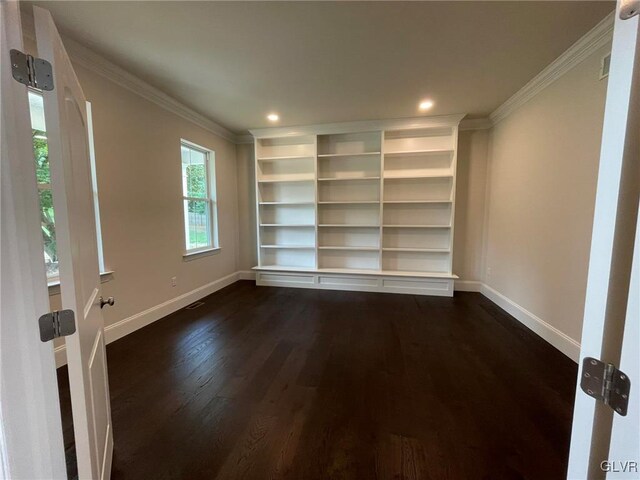 empty room with ornamental molding and dark hardwood / wood-style flooring