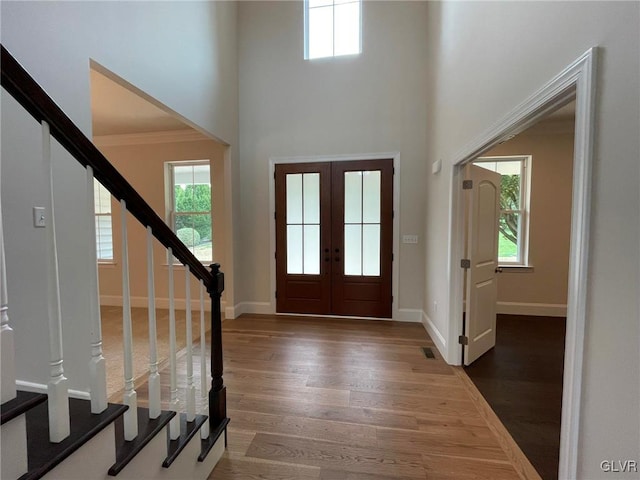 foyer entrance with plenty of natural light, dark wood-type flooring, and french doors