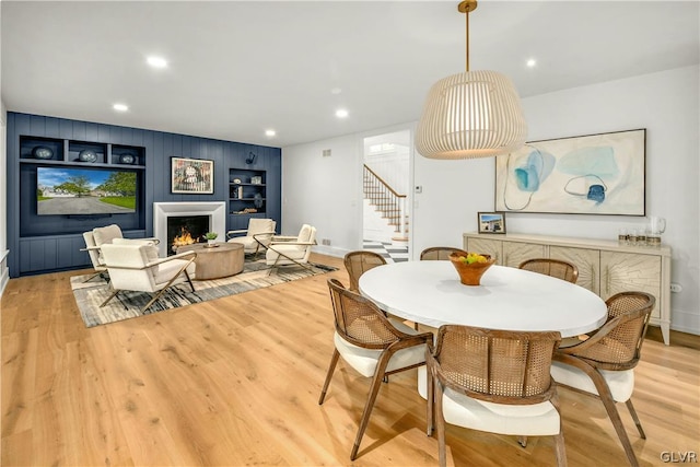 dining room with light hardwood / wood-style flooring and built in features