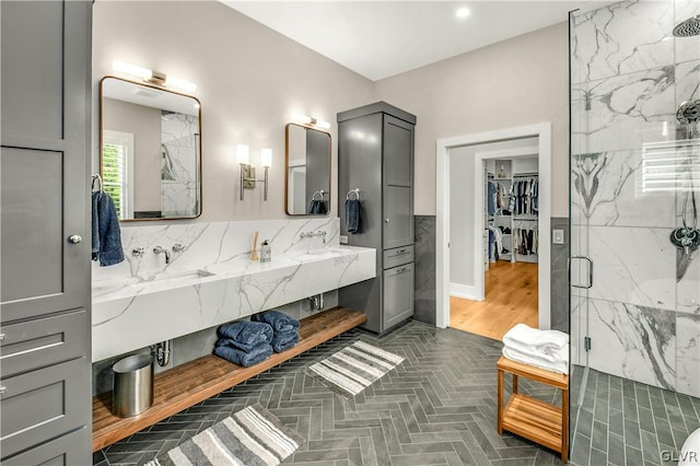 bathroom with vanity, a shower with shower door, and tile walls