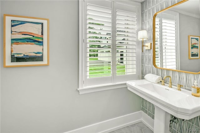 bathroom with tile patterned flooring, sink, plenty of natural light, and ornamental molding