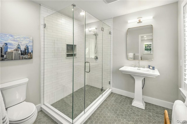 bathroom featuring tile patterned floors, toilet, and a shower with door