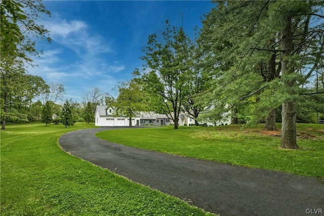 surrounding community featuring a garage and a lawn