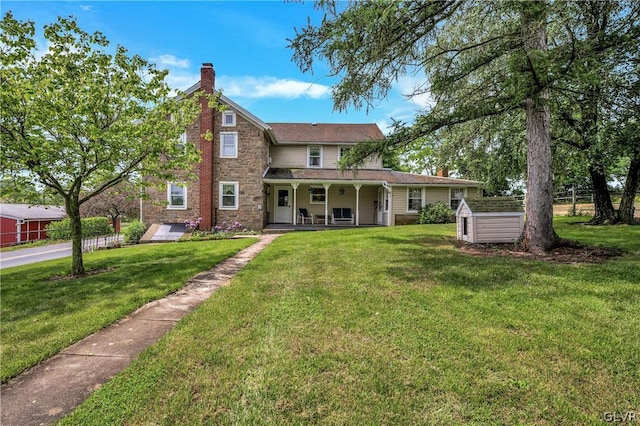 view of front of house featuring a shed and a front lawn