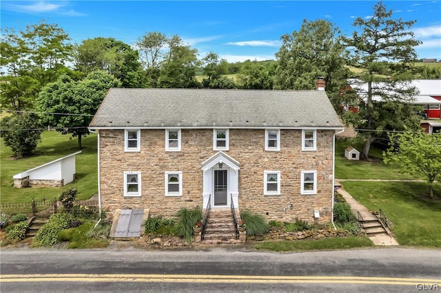 colonial home featuring a front yard