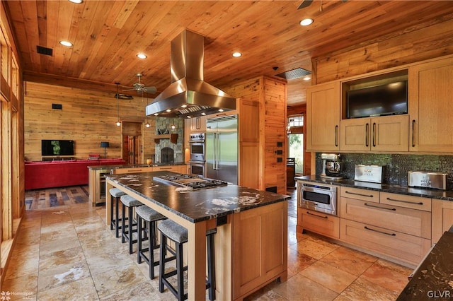 kitchen featuring island exhaust hood, light tile patterned floors, a breakfast bar area, a center island, and stainless steel appliances