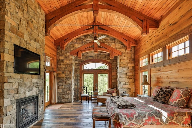 unfurnished bedroom with wood ceiling, high vaulted ceiling, hardwood / wood-style floors, french doors, and a fireplace