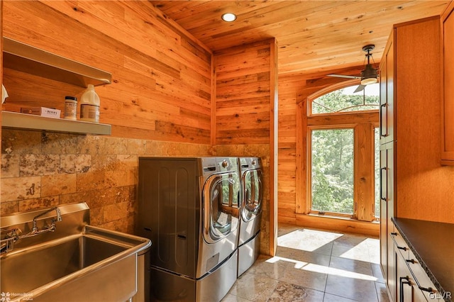 laundry area featuring ceiling fan, wooden walls, sink, and light tile patterned floors