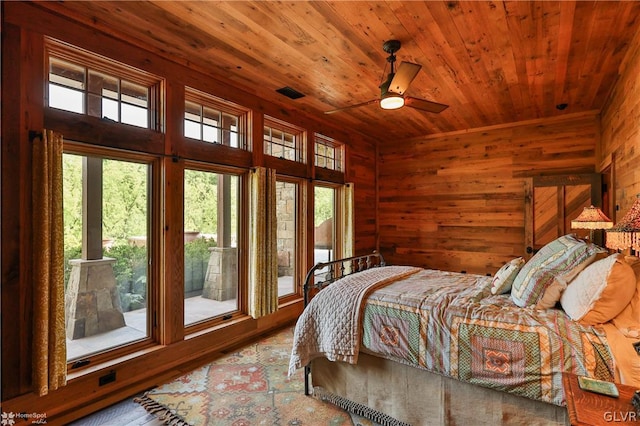 bedroom with wood ceiling, ceiling fan, wooden walls, and hardwood / wood-style floors