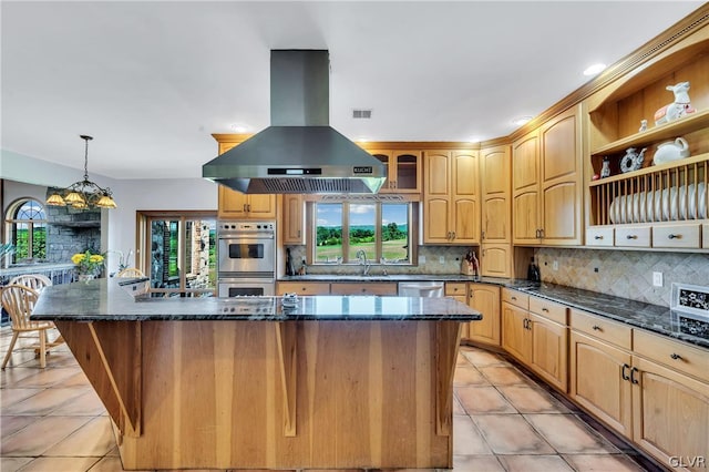 kitchen with island range hood, a sink, a kitchen island, appliances with stainless steel finishes, and decorative backsplash