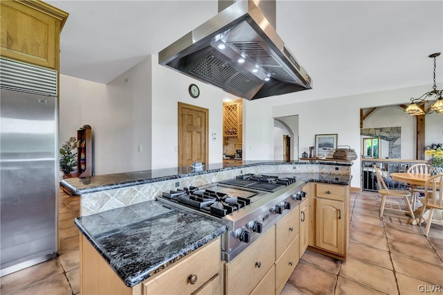 kitchen with arched walkways, appliances with stainless steel finishes, hanging light fixtures, ventilation hood, and light brown cabinetry