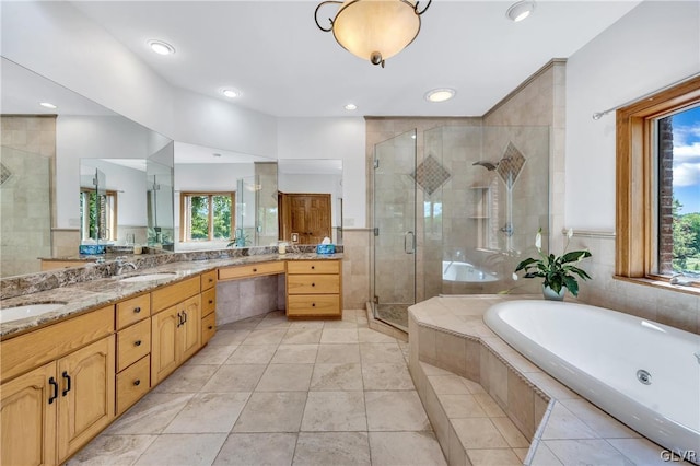 full bathroom with double vanity, a sink, a shower stall, a bath, and tile patterned floors