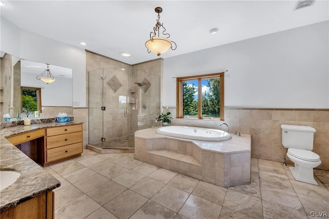 bathroom featuring a wainscoted wall, tile walls, a stall shower, vanity, and a bath