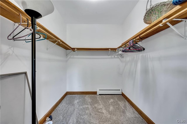 spacious closet with a baseboard heating unit and carpet