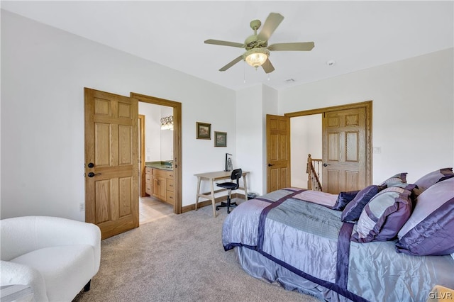 bedroom featuring light carpet, ensuite bath, ceiling fan, and baseboards