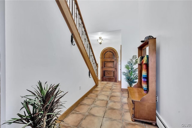 foyer entrance with baseboards, stairway, and baseboard heating