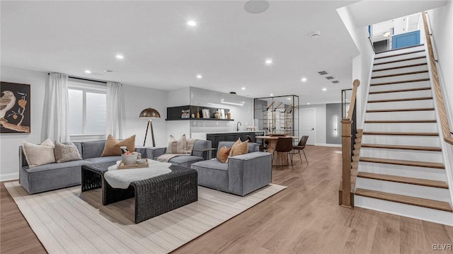 living room featuring light wood-type flooring and indoor bar