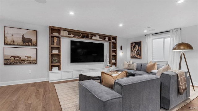 living room with hardwood / wood-style floors and built in shelves