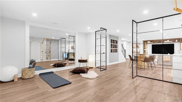 workout area with light hardwood / wood-style floors