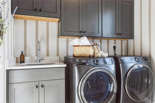 clothes washing area with cabinets, separate washer and dryer, and sink