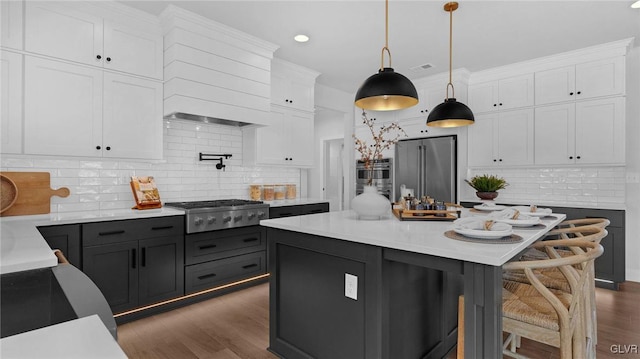 kitchen featuring white cabinets, decorative backsplash, pendant lighting, and appliances with stainless steel finishes