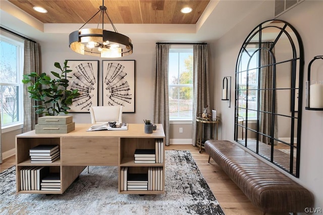 home office with a healthy amount of sunlight, light hardwood / wood-style floors, a raised ceiling, and wooden ceiling