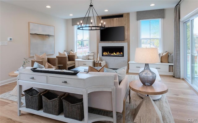 living room with light hardwood / wood-style floors, a fireplace, and plenty of natural light