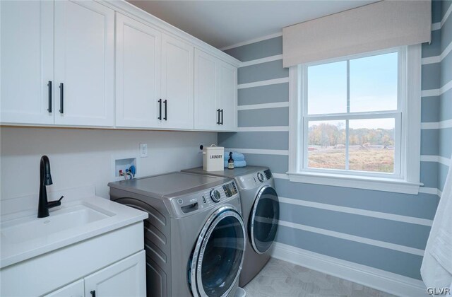 laundry area with washing machine and clothes dryer, sink, and cabinets