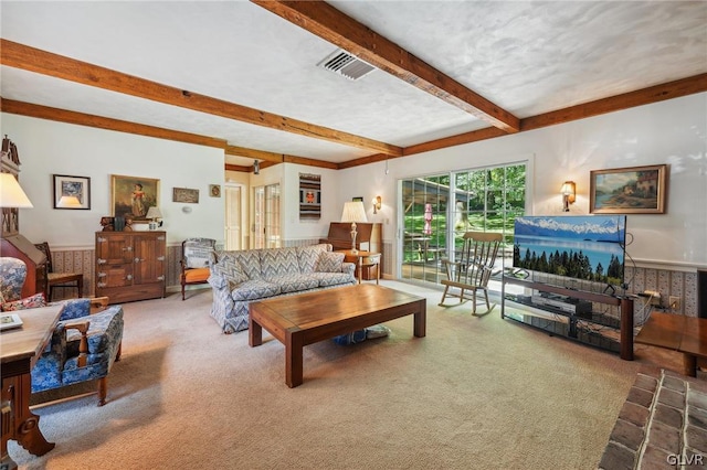 living room featuring carpet floors, a textured ceiling, visible vents, and beamed ceiling