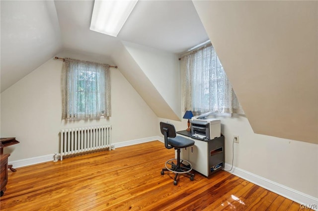 office area with lofted ceiling, radiator heating unit, baseboards, and wood finished floors