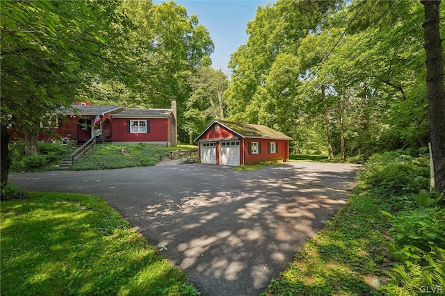 view of front of home with an outdoor structure and a detached garage