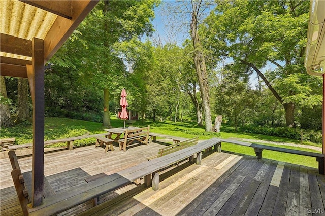 deck featuring outdoor dining space and a lawn