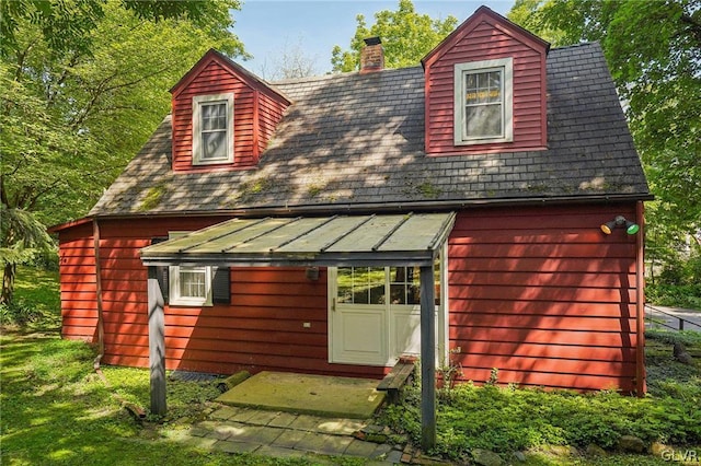 rear view of house featuring a chimney