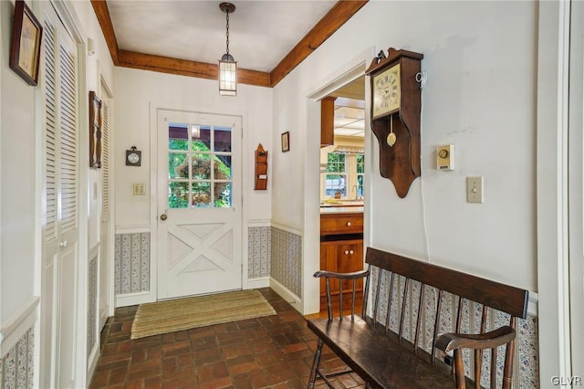 foyer featuring brick floor and wainscoting